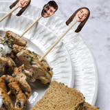 Skewers with faces on them over a plate of food