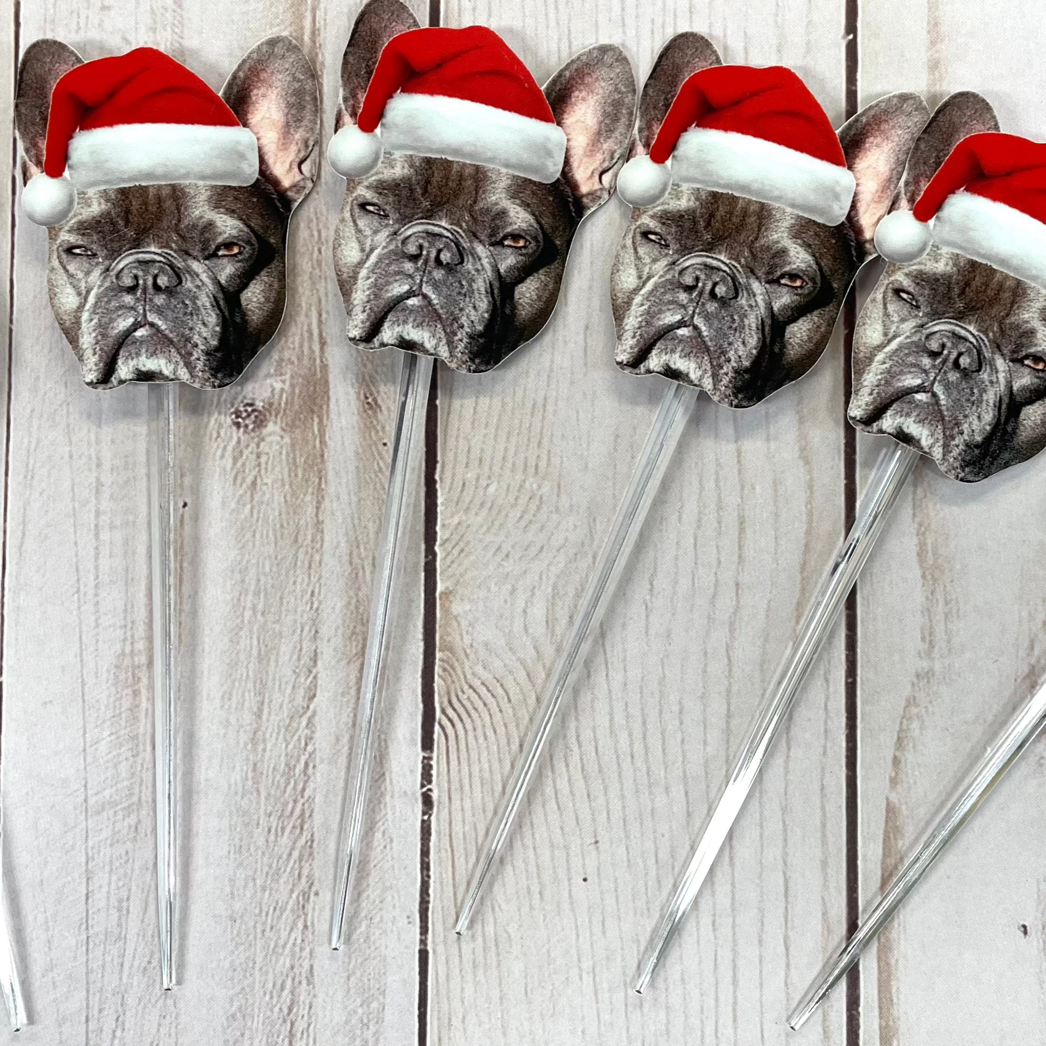 Cut out a french bulldogs face wearing a santa hat stuck on clear cocktail picks