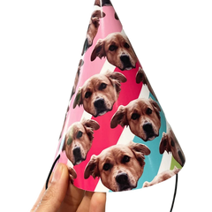 A colorful striped party hat with a dogs face scattered over it