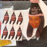 Vinyl stickers and a banner featuring smiling woman wearing a black hat with glitter gold text that says "the legend has retired" custom photo decorations for a retirement party