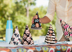 A variety of colorful party hats featuring different face patterns displayed on a table