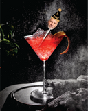 retirement cocktail picks clear acrylic cocktail stick with a man's face wearing a black and gold sparkle party hat that says "I'm Retired!" in a martini glass with s black speckle background