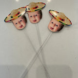 baby's face cut out wearing a sombrero on a drink stir stick
