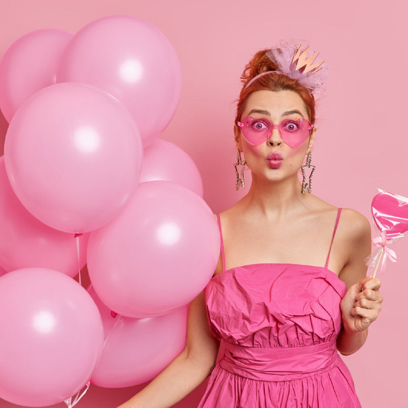 bride to be in a pink dress with pink sunglasses and pink balloons ready to celebrate her bachelorette party!