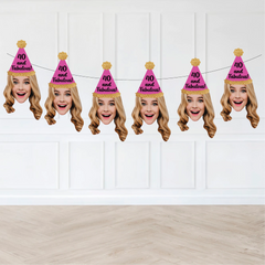 blond woman wearing a pink party hat that says "40 and fabulous!" hanging on a strung banner against a wall