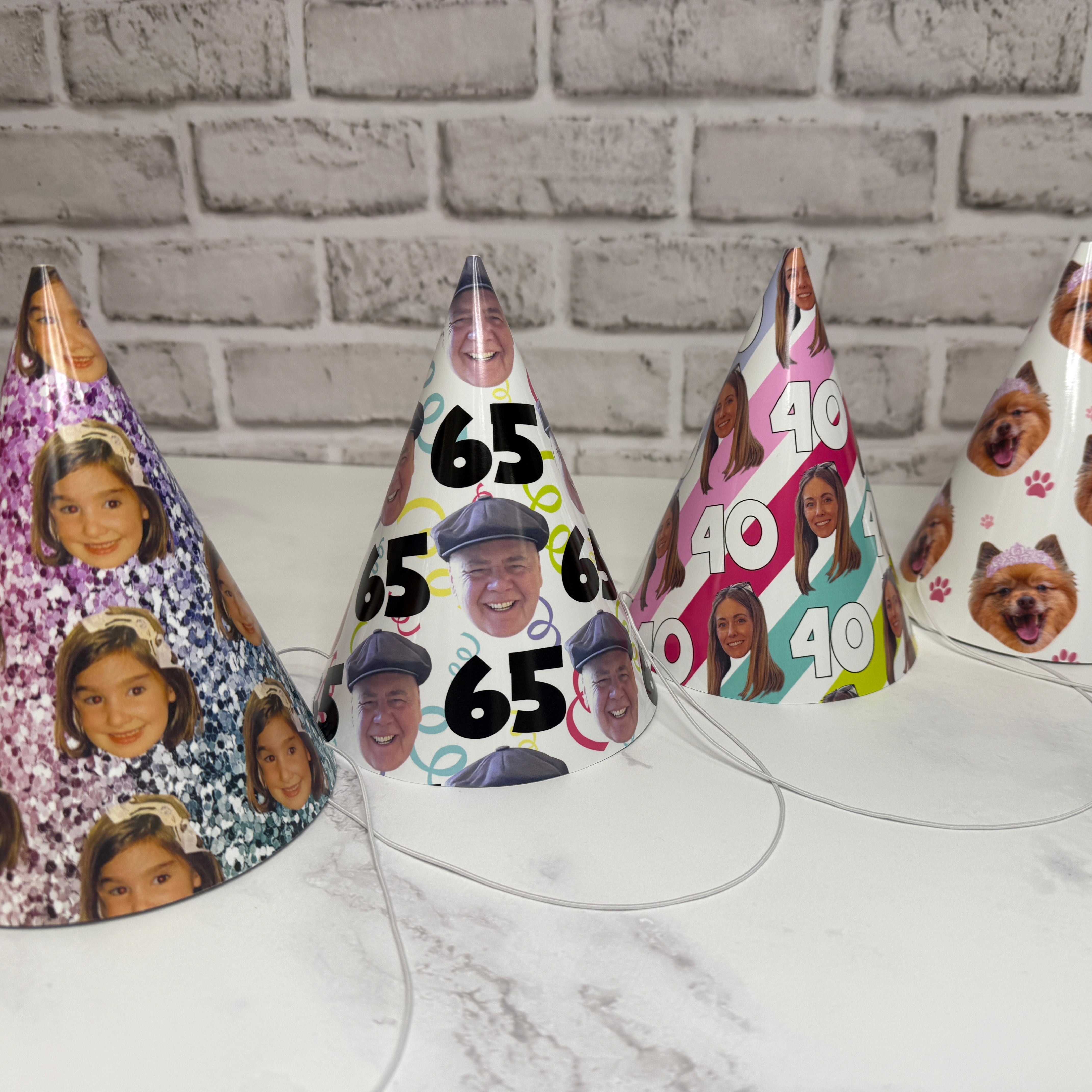Set of personalized party hats with various designs on a marble surface.