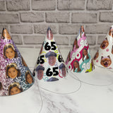 Set of personalized party hats with various designs on a marble surface.