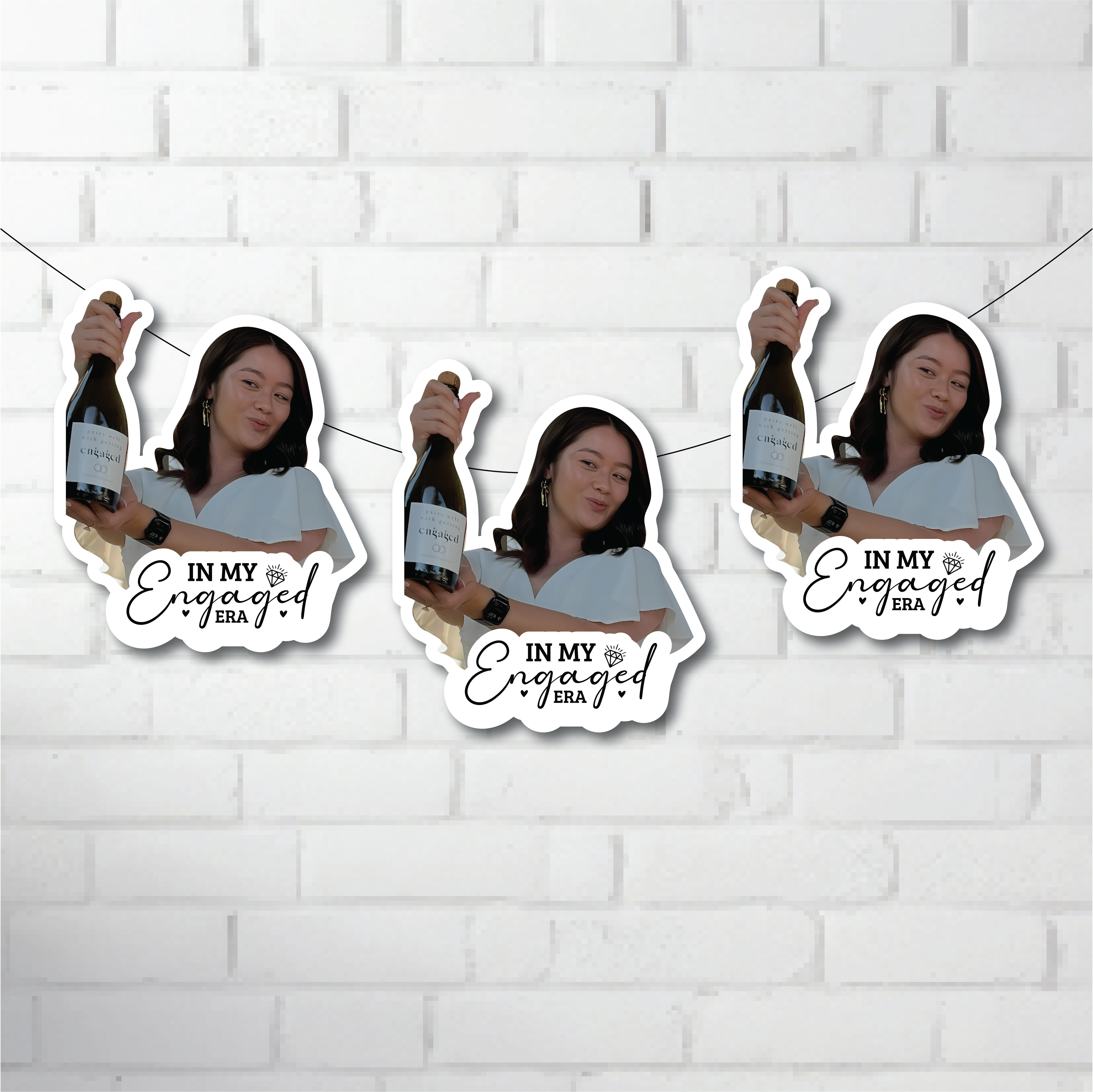 Three cut outs of a person holding a bottle with 'In My Engaged Era' text on a white brick wall background.