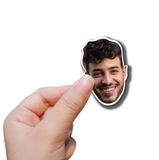 Hand holding a single vinyl photo sticker of a young mans face