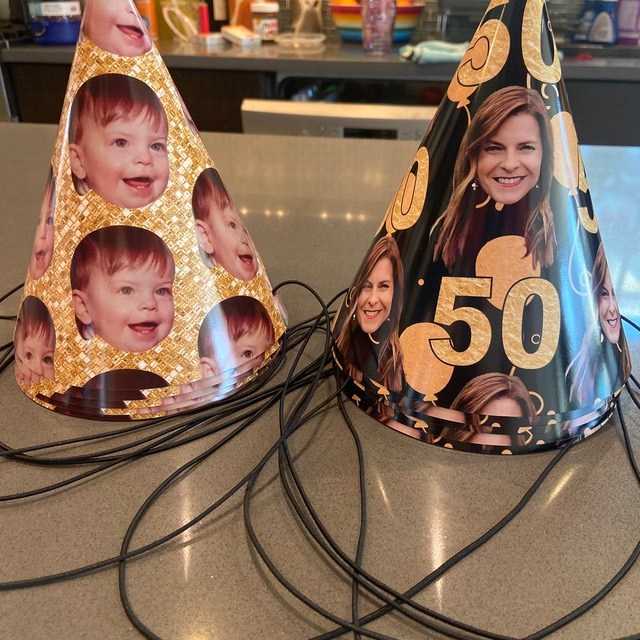 black and gold party hats with faces on a table