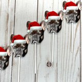 A series of custom photo cupcake toppers featuring a french bulldog wearing a Santa hat, printed on photo paper and attached to lollipop sticks.