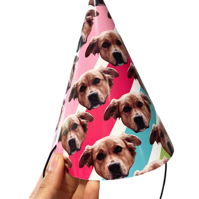 A colorful striped party hat with a dogs face scattered over it