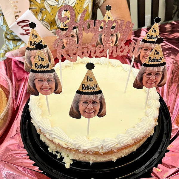 Birthday cake withRetirement-themed face cutouts and 'Happy Retirement' topper.