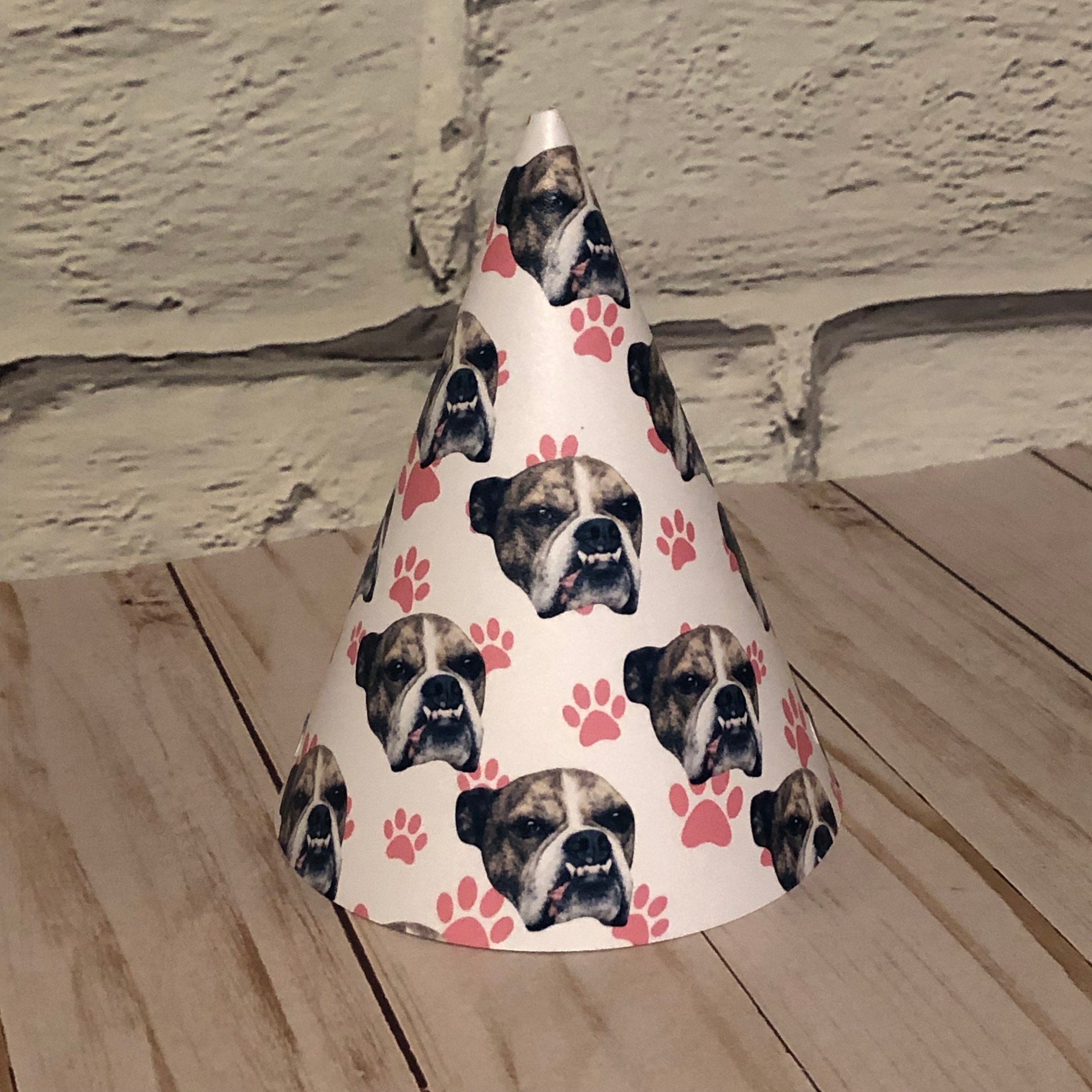 a paw print party hat with a bulldogs face scattered over it displayed on a table