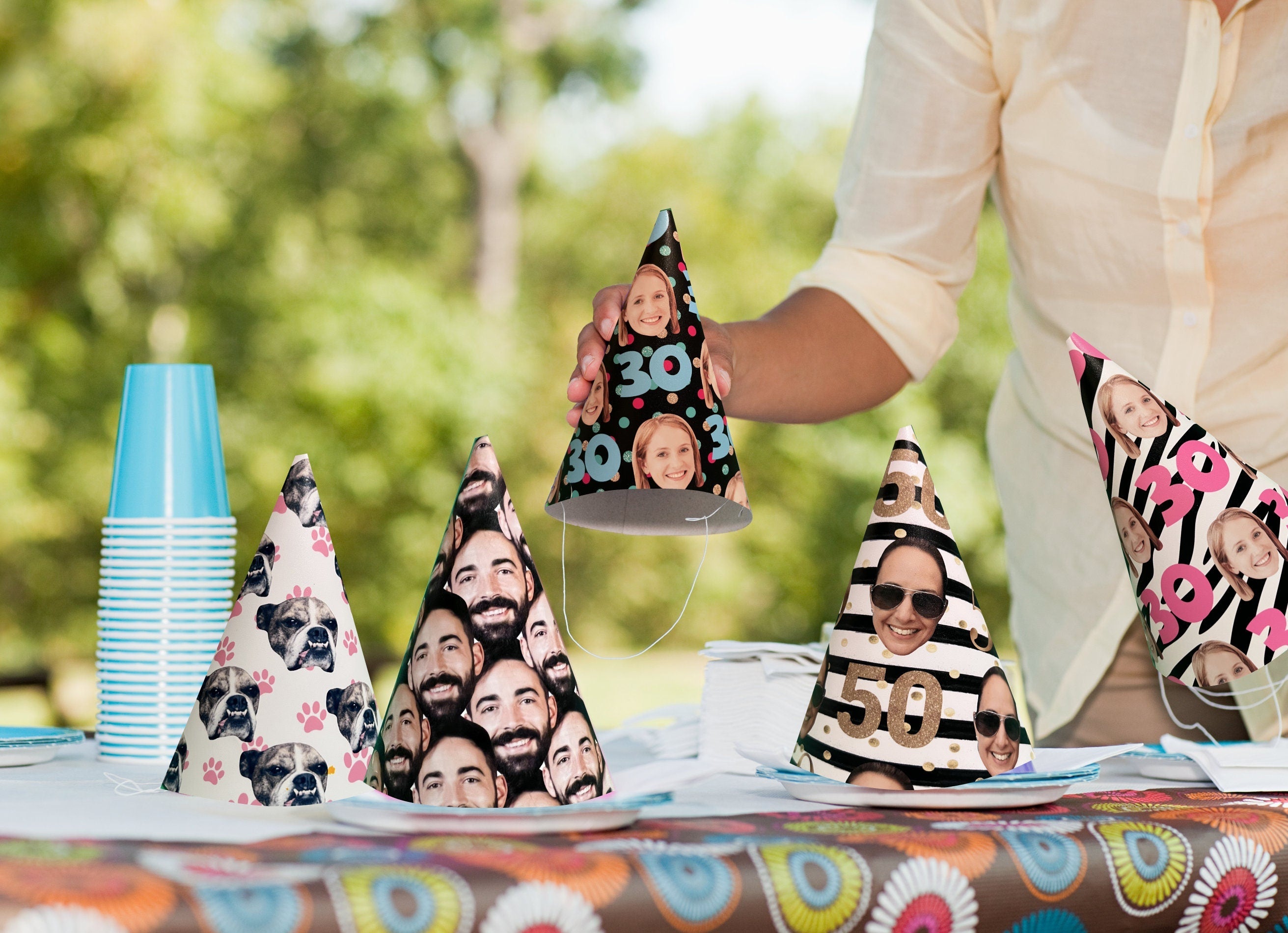 A variety of colorful party hats featuring different face patterns displayed on a table