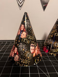 a black party hat with gold text reading happy new year, fireworks and peoples faces