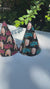 two happy retirement cone hats sitting on a party table outside in front of a green hedge