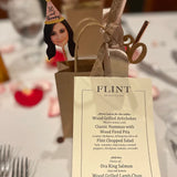 woman wearing a party hat that says 30 and thriving party accessories on a table